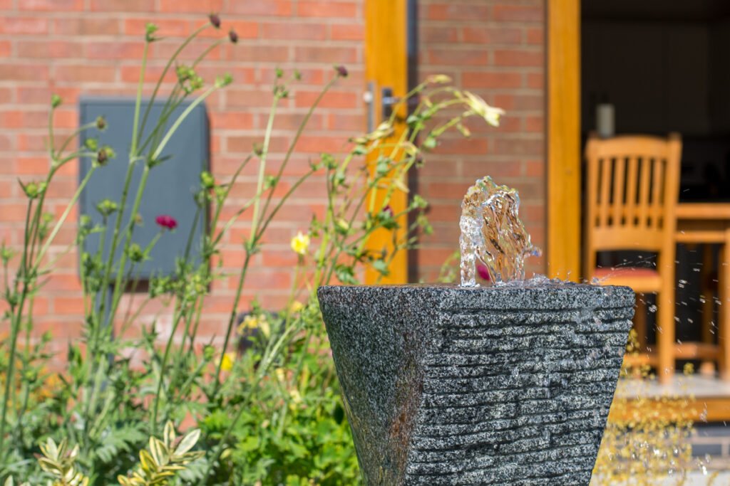 Focal point water feature invites exploration and movement through a small garden.