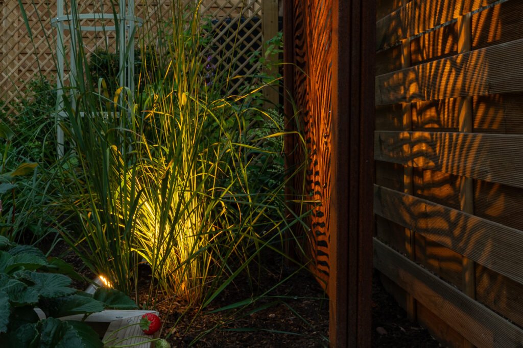 Small garden lighting with uplight creating depth and evening atmosphere