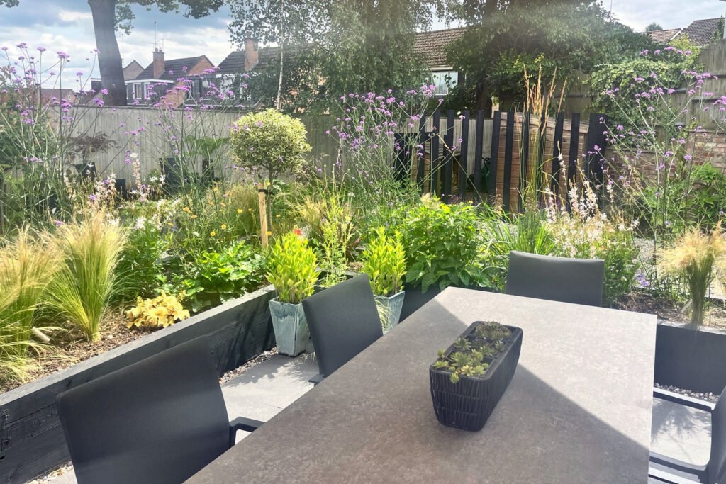 Small garden divided into zones with dining area, planting beds, utility space and relaxing sun spot for a spacious feel.